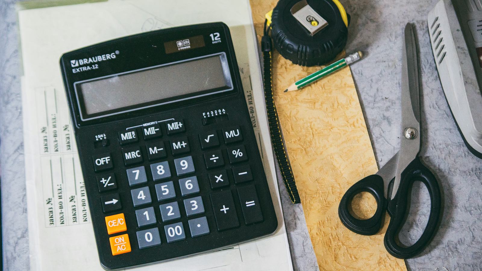 A calculator and office supplies arranged on a desk