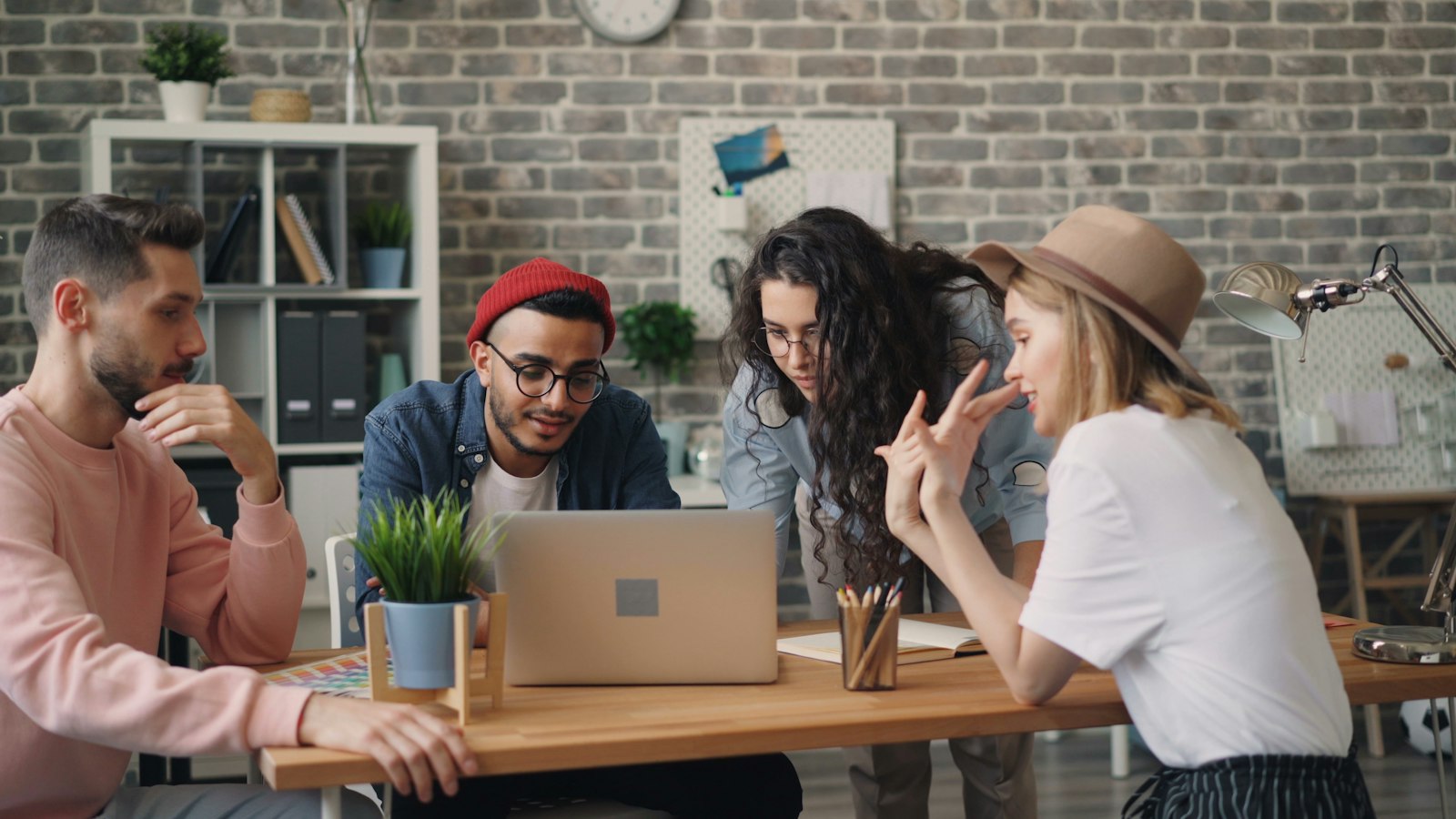 A group of colleagues sitting around a wooden table in conversation