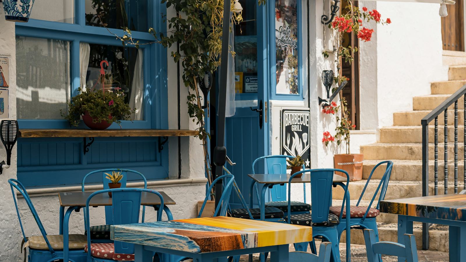 A blue-themed outdoor cafe with tables and chairs